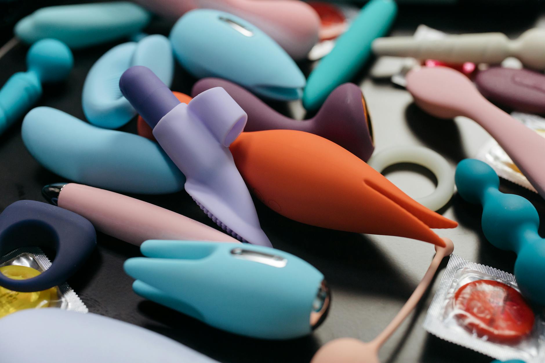 Un vibrador azul rodeado de flores y naranjas sobre fondo amarillo brillante