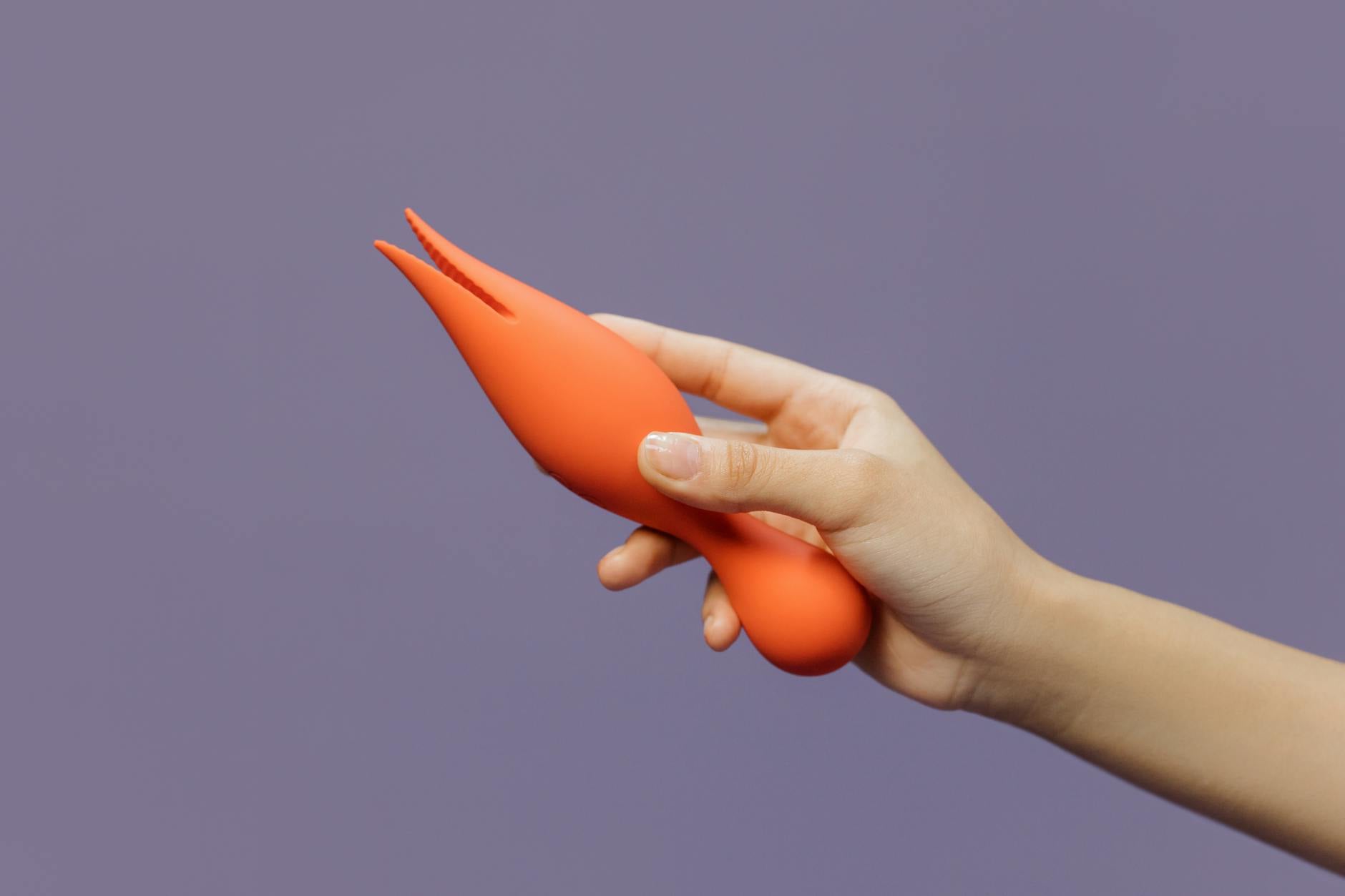 Mano sosteniendo un vibrador de limón contra un fondo minimalista, mostrando la estimulación moderna y sensual
