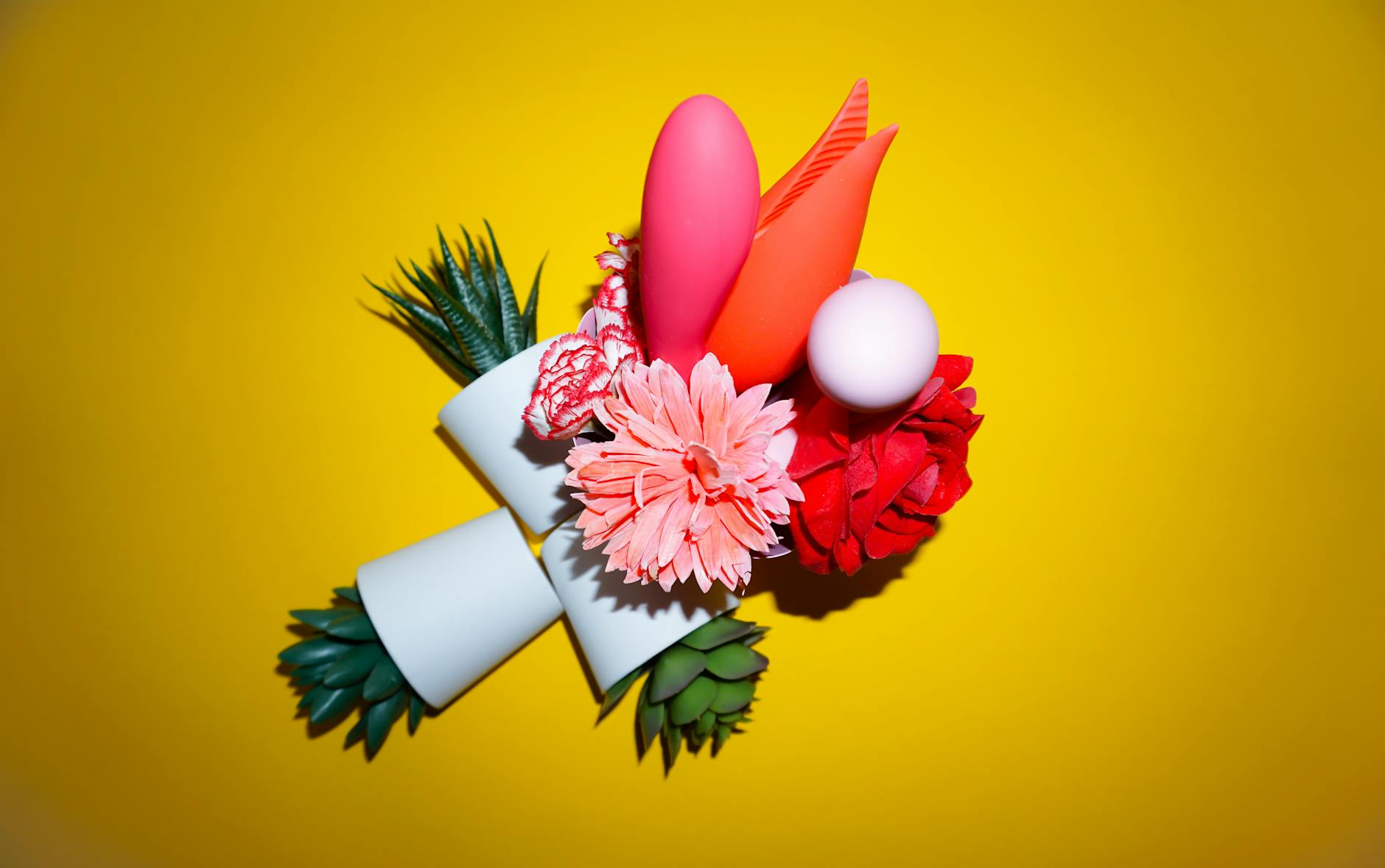 Primer plano de una mano sosteniendo un vibrador naranja contra un fondo minimalista púrpura, mostrando sensualidad moderna.