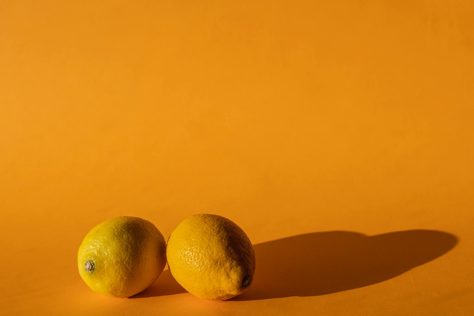Vibrador azul rodeado de flores y naranjas sobre fondo amarillo brillante